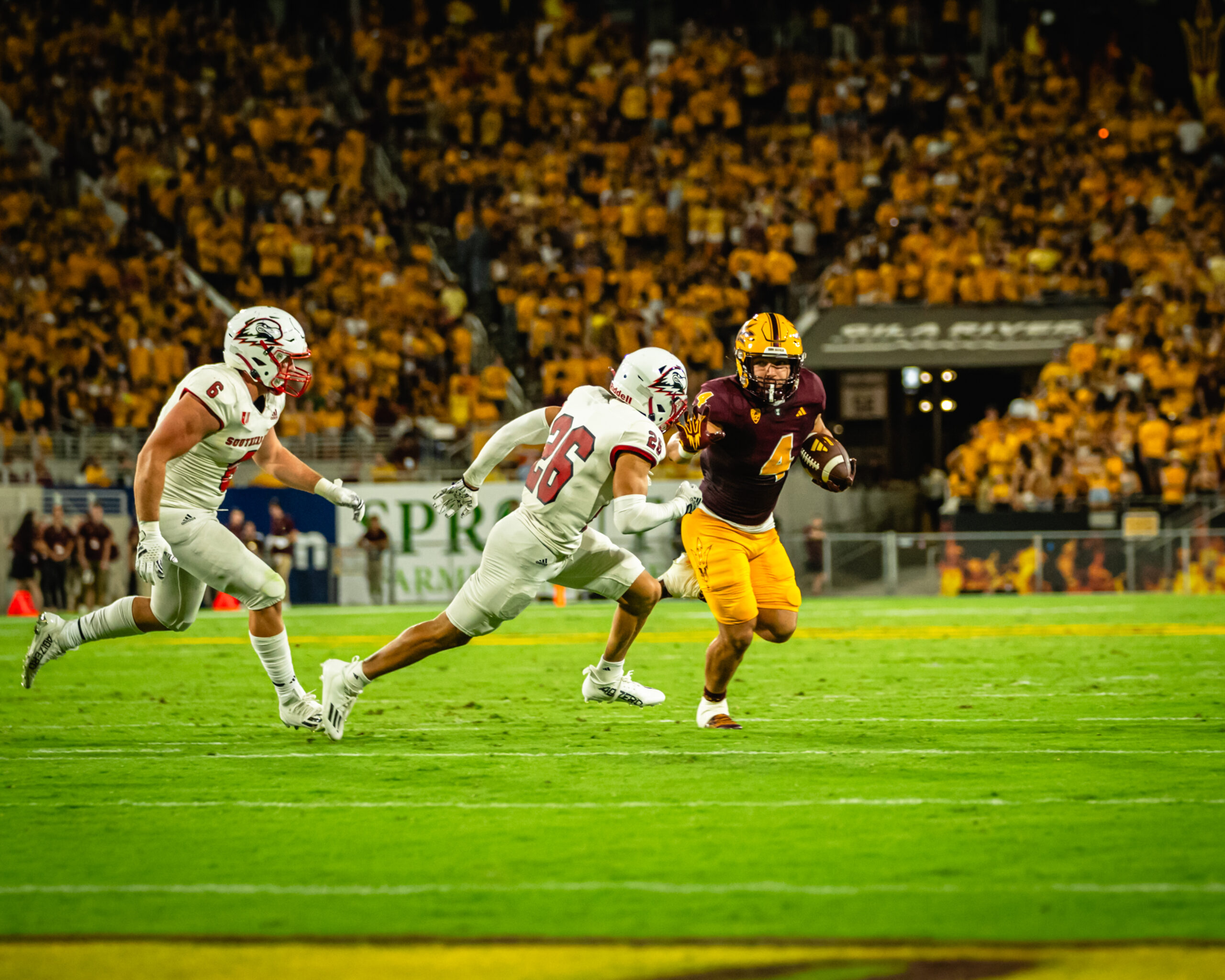 Cameron Skattebo stiff arms a Southern Utah defender.