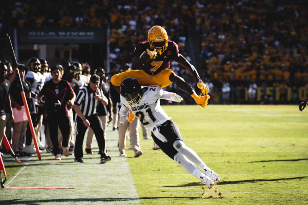 Arizona State football player hurdles Colorado player.