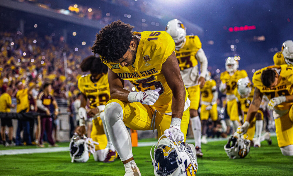 An ASU football player kneels before the Sun Devils' game against Mississippi State.