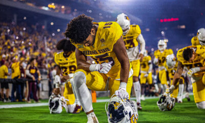 An ASU football player kneels before the Sun Devils' game against Mississippi State.