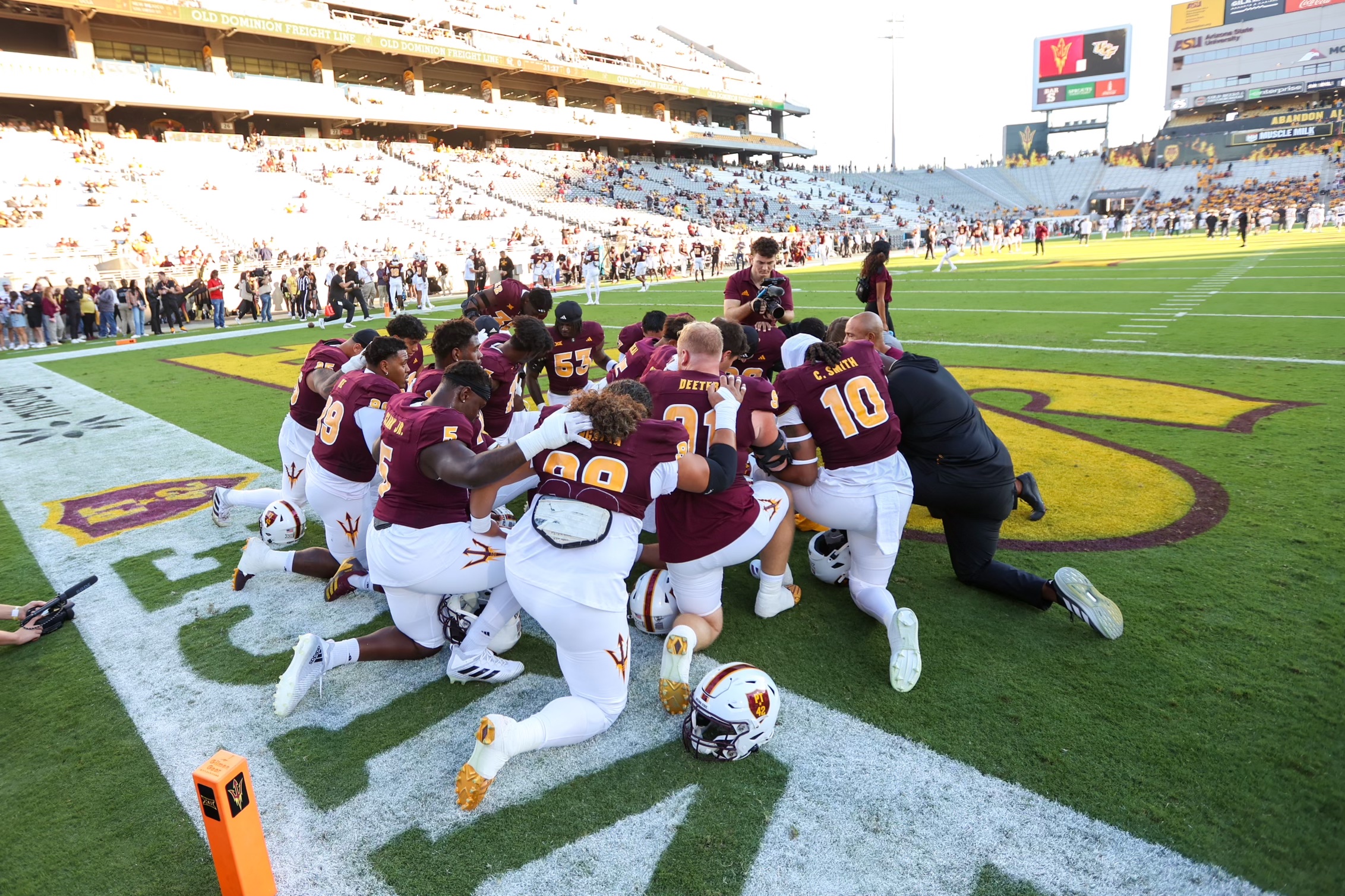 ASU football players huddle pregame.