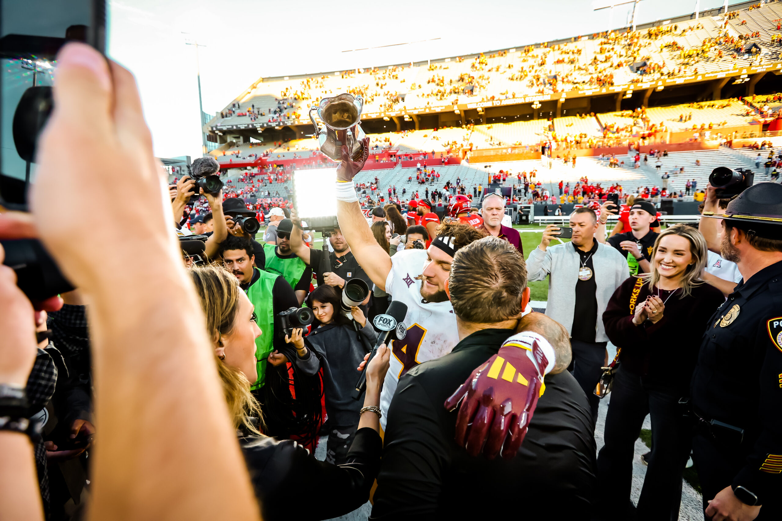 Arizona State's Cam Skattebo hoists the Territorial Cup after a win at Arizona Stadium on Nov. 30, 2024. The Territorial Cup Trophy is annually given to the winning team in the rivalry showdown between Arizona State and Arizona. (Photo by Sedona Levy/Sun Devil Daily)