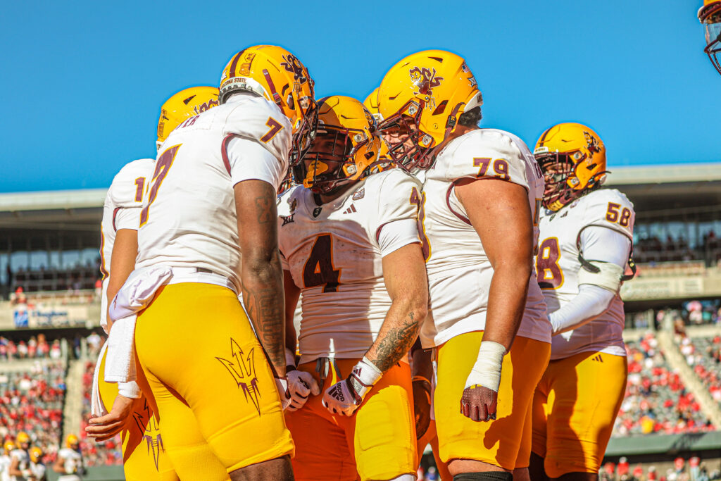 Arizona State running back Cam Skattebo is surrounded by teammates in a game against Arizona.